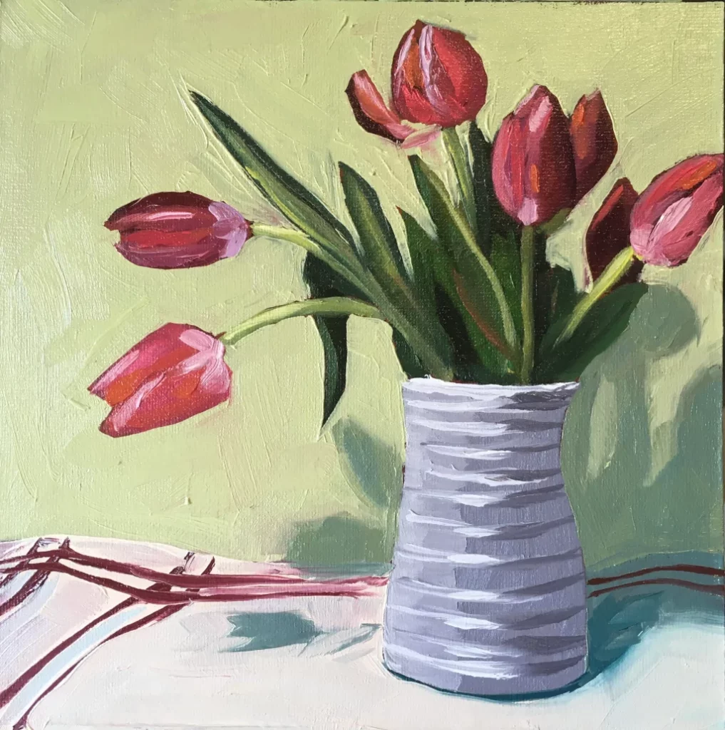 Oil painting of pink tulips in a white vase resting on a striped tea towel.